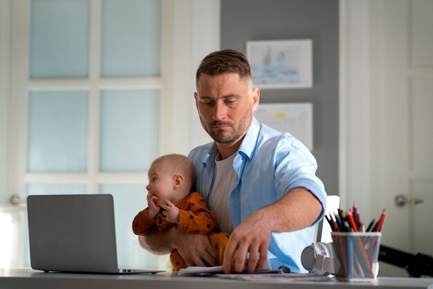 Father working from home trying to balance family life with child and job