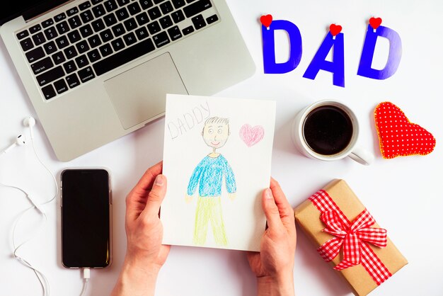 Free Photo fathers day composition with laptop and kids drawing 