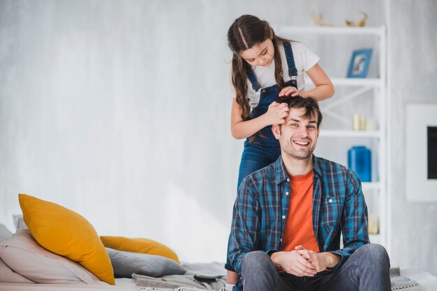 Fathers day concept with daughter cutting fathers hair