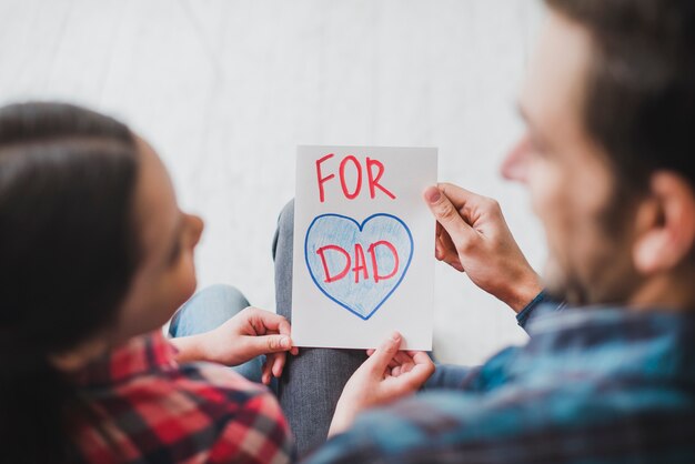 Fathers day concept with father and daughter looking at hand drawn card