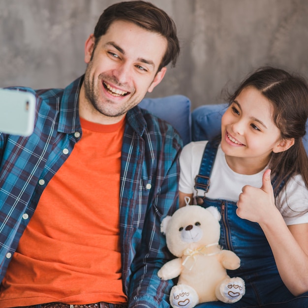 Free photo fathers day concept with father and daughter taking selfie