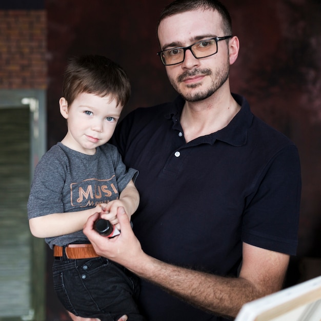 Free photo fathers day concept with father and son in front of canvas