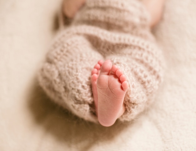 Free photo feet of dreamy child enveloped in woolen scarf