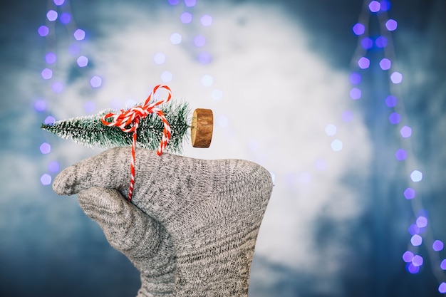 Feet holding toy christmas tree