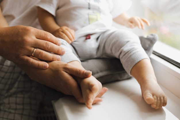 The feet of a little boy in the arms of his parents