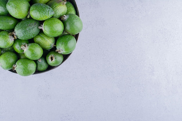 Feijoas piled into a metal vase on marble background. High quality photo