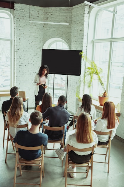 Female african-american speaker giving presentation in hall at university workshop