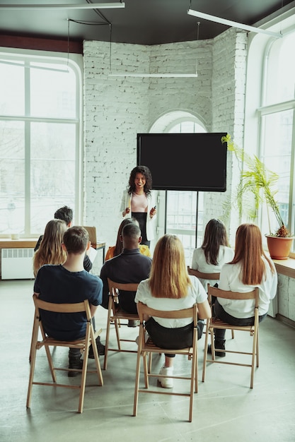 Free Photo female african-american speaker giving presentation in hall at university workshop