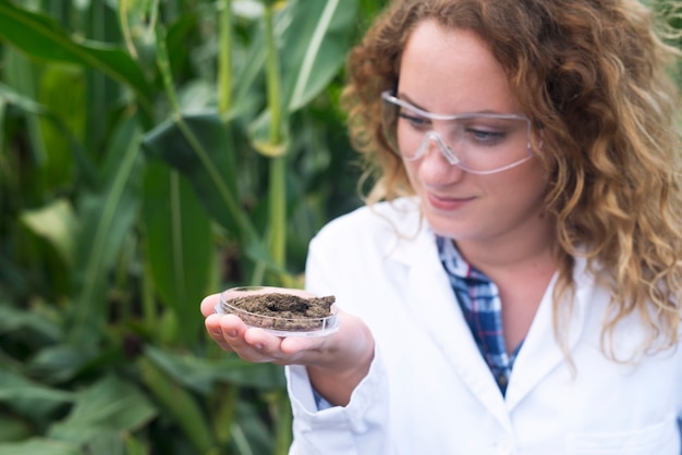 Free photo female agronomist specialist examining soil sample for fertility potential