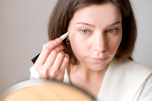 Female applying eye concelear