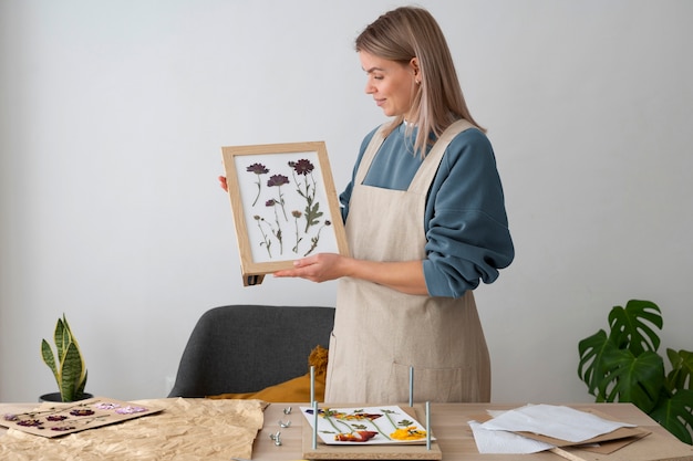 Female artisan with frame made of pressed flowers