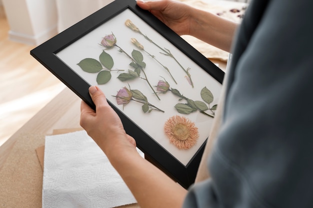 Female artisan with frame made of pressed flowers