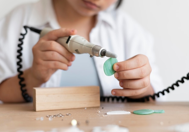 Female artisan working in the atelier with glue gun