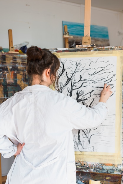 Free Photo female artist drawing creatively on canvas with charcoal