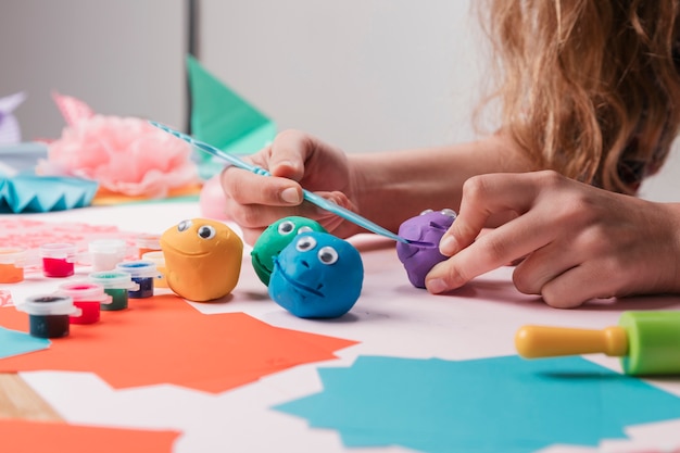 Female artist hand making cartoon faces using craft equipment