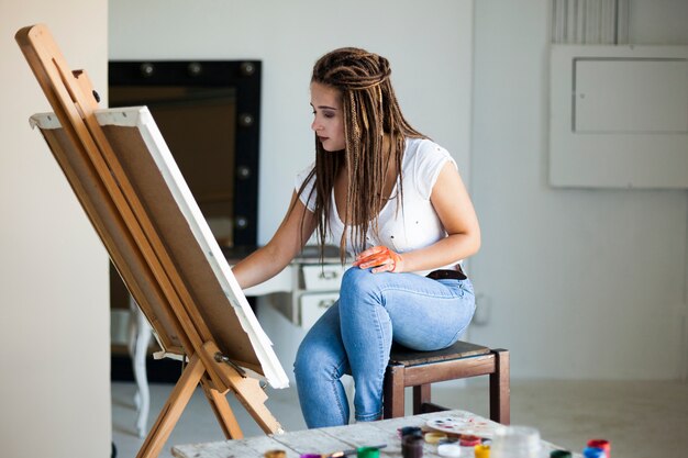 Female artist painting on canvas in studio