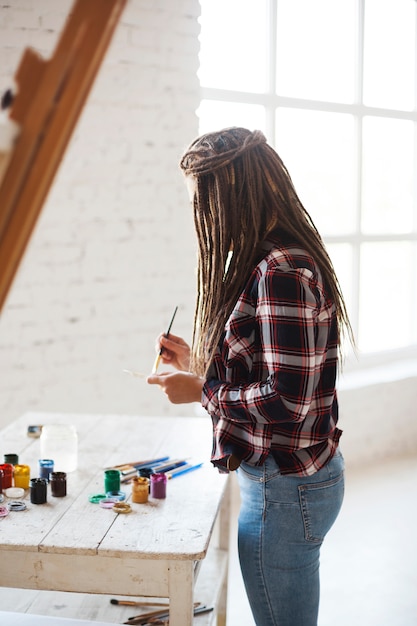 Free photo female artist painting indoors