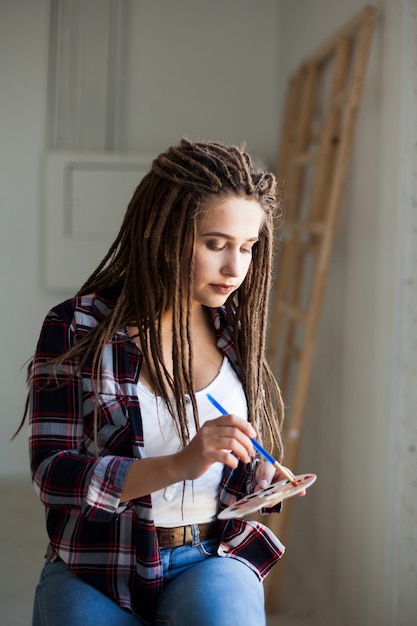 Free photo female artist painting indoors