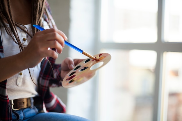 Free photo female artist painting indoors