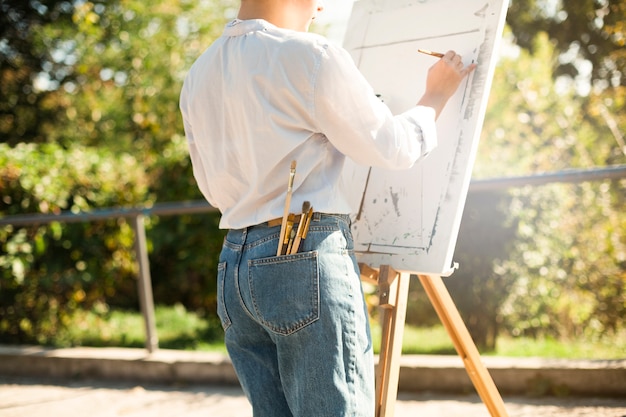 Free photo female artist painting outdoors