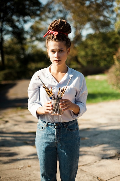 Free photo female artist painting outdoors