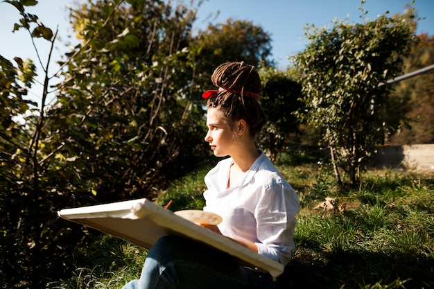 Female artist painting outdoors