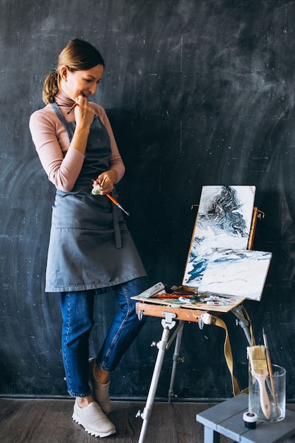 Free photo female artist painting in studio