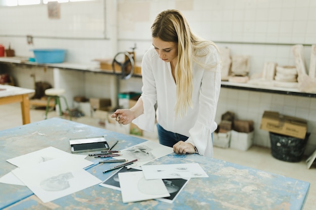 Female artist working with sketches on white paper