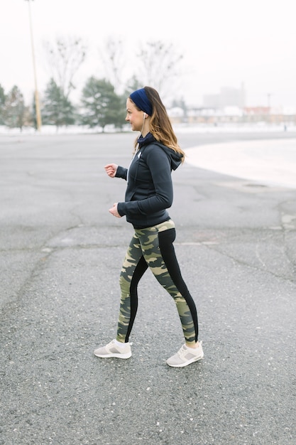 Female athlete exercising on street in winter