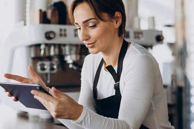 Female barista with tablet making order in a coffee shop