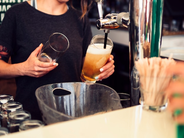 Free Photo female bartender pouring beer