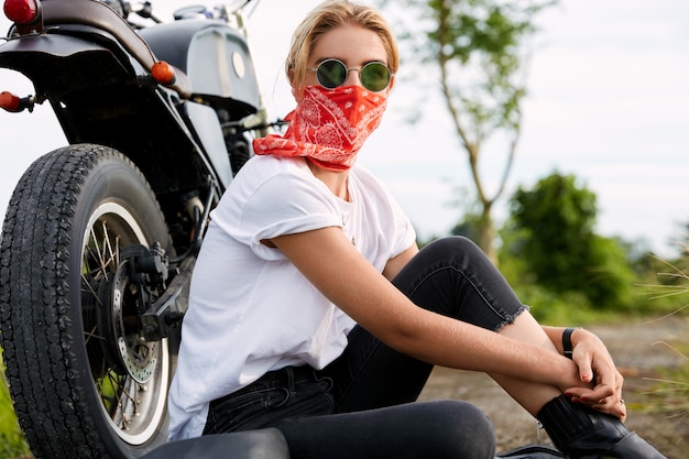 Free photo female biker sitting next to motorbike