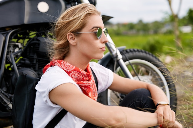 Free photo female biker sitting next to motorbike