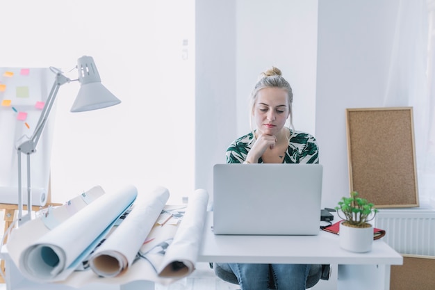 Free photo female businesswoman working on laptop at workplace