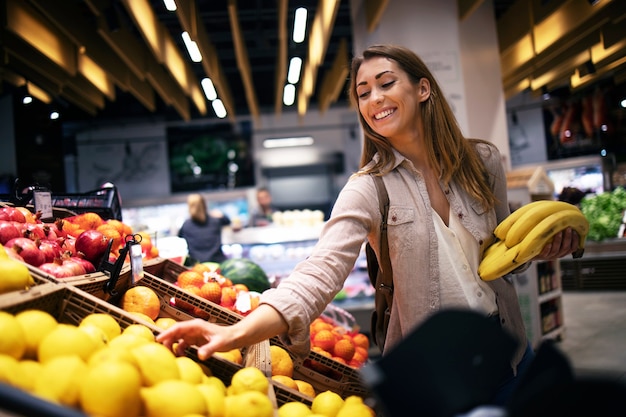 Free photo female buying food at supermarket grocery store