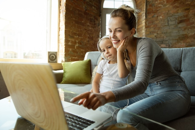 Female caucasian teacher and little girl, or mom and daughter. Homeschooling