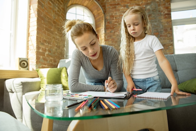 Free photo female caucasian teacher and little girl, or mom and daughter.