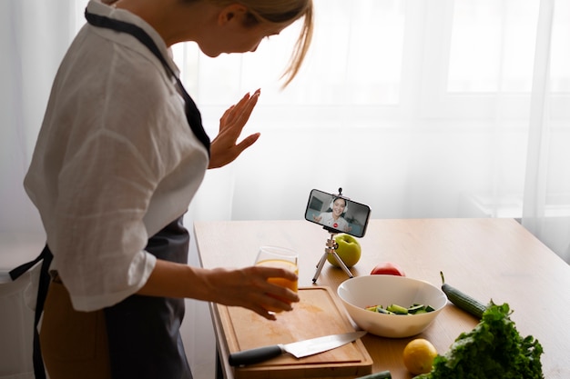 Free photo female chef having a videocall while cooking