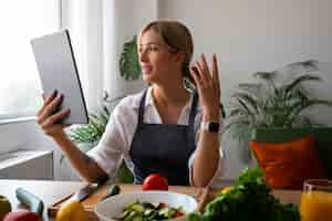 Free photo female chef having a videocall while cooking