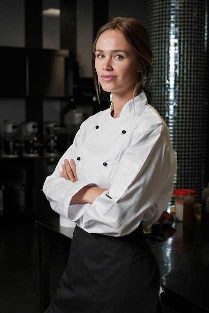 Free photo female chef in the kitchen dressed in apron and uniform