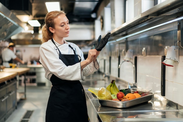 Female chef putting on glove in the kitchen