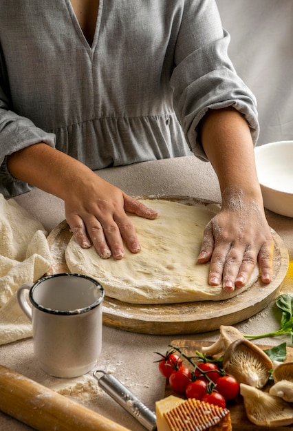 Female chef stretching pizza dough