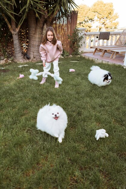 Female child and fluffy dog playing