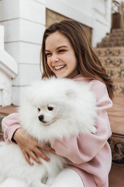 Free Photo female child hugging her fluffy dog