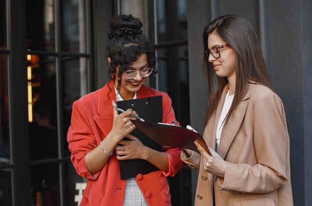 Female colleagues discussing data in the cafe outdoor. 