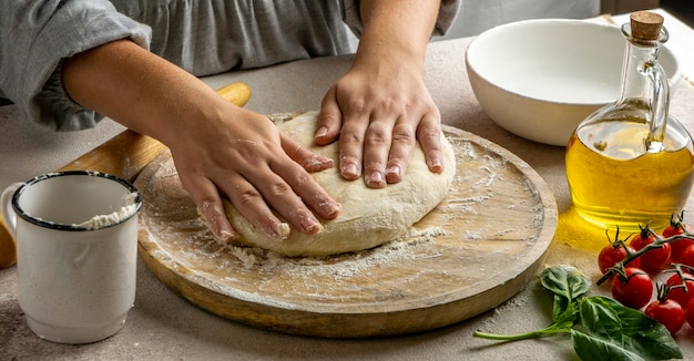 Female cook preparing pizza dough