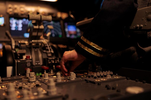 Female copilot switching control panel buttons on dashboard command, using radar compass on windscreen in cockpit cabin. Airliner flying plane jet with travel navigation. Close up.