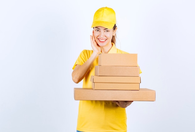 Female courier delivering a stock of cardboard boxes. 