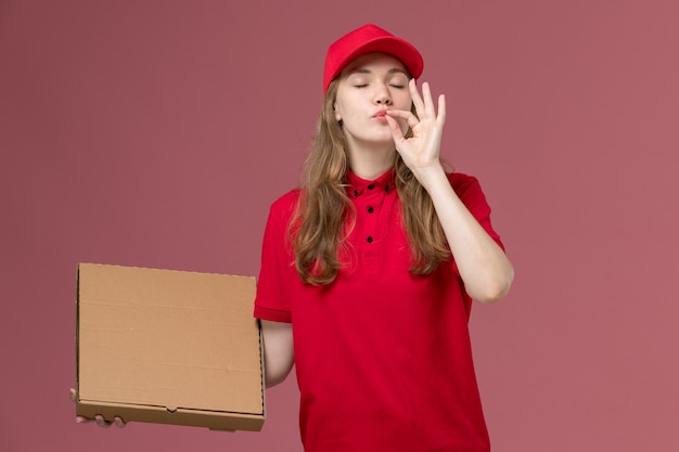 female courier in red uniform holding food box on pink, uniform service delivery job worker