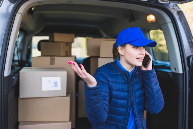 Female courier talking on phone in car